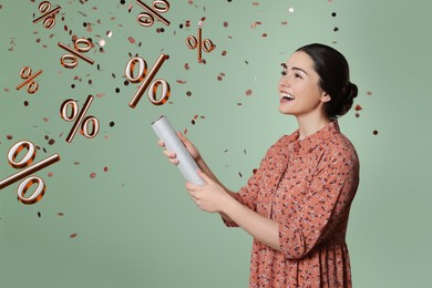 Image of Discount offer. Happy young woman blowing up party popper on color background. Confetti and percent signs in air