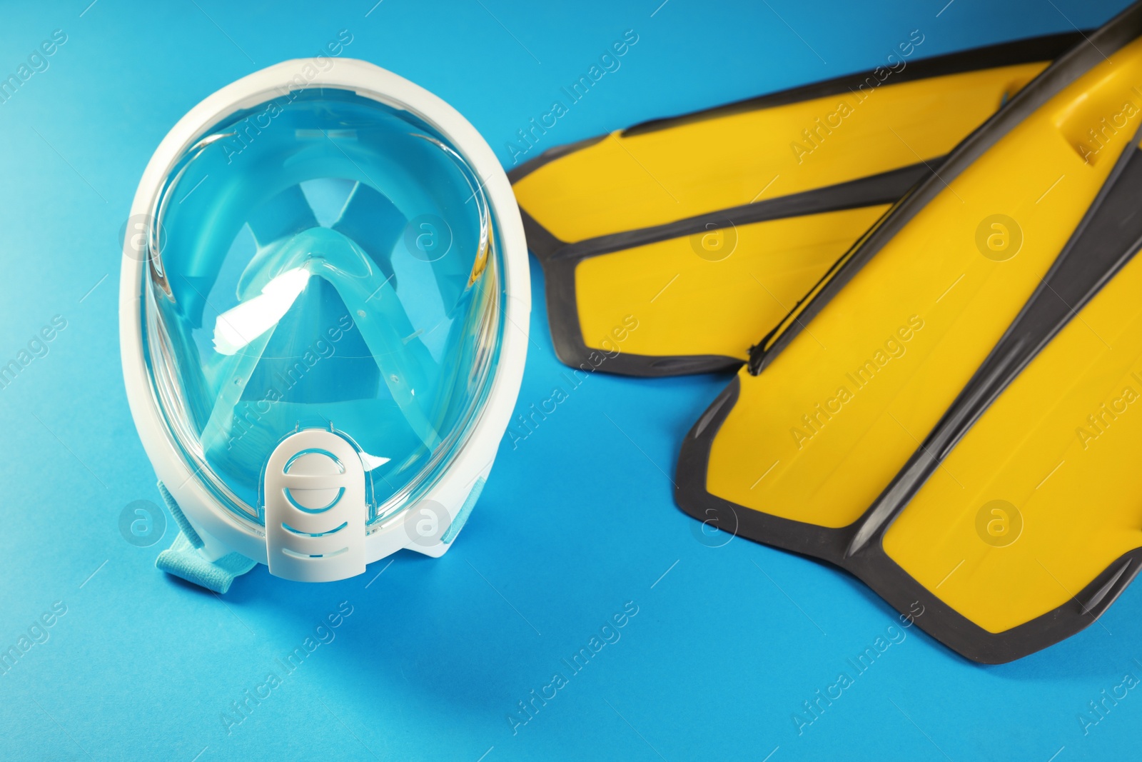 Photo of Pair of yellow flippers and diving mask on color background