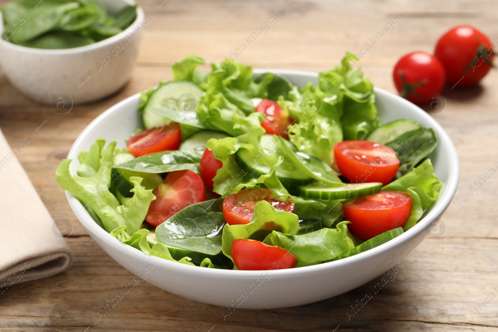 Photo of Delicious vegetable salad on wooden table, closeup