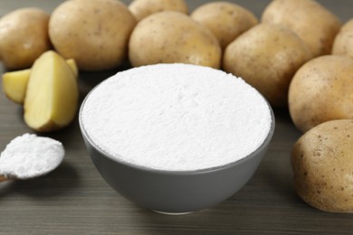 Starch and fresh potatoes on wooden table, closeup