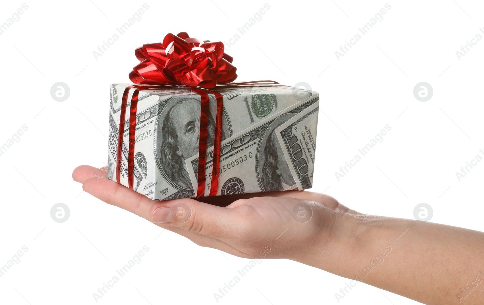 Photo of Woman holding gift box wrapped in decorative paper with dollar pattern on white background, closeup