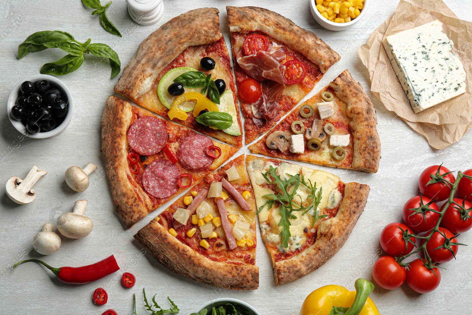 Photo of Flat lay composition with slices of different delicious pizzas on light grey table