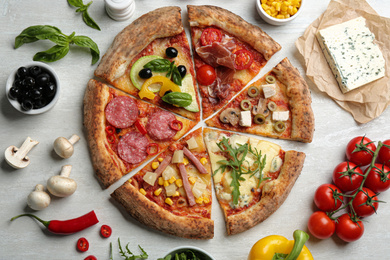 Flat lay composition with slices of different delicious pizzas on light grey table