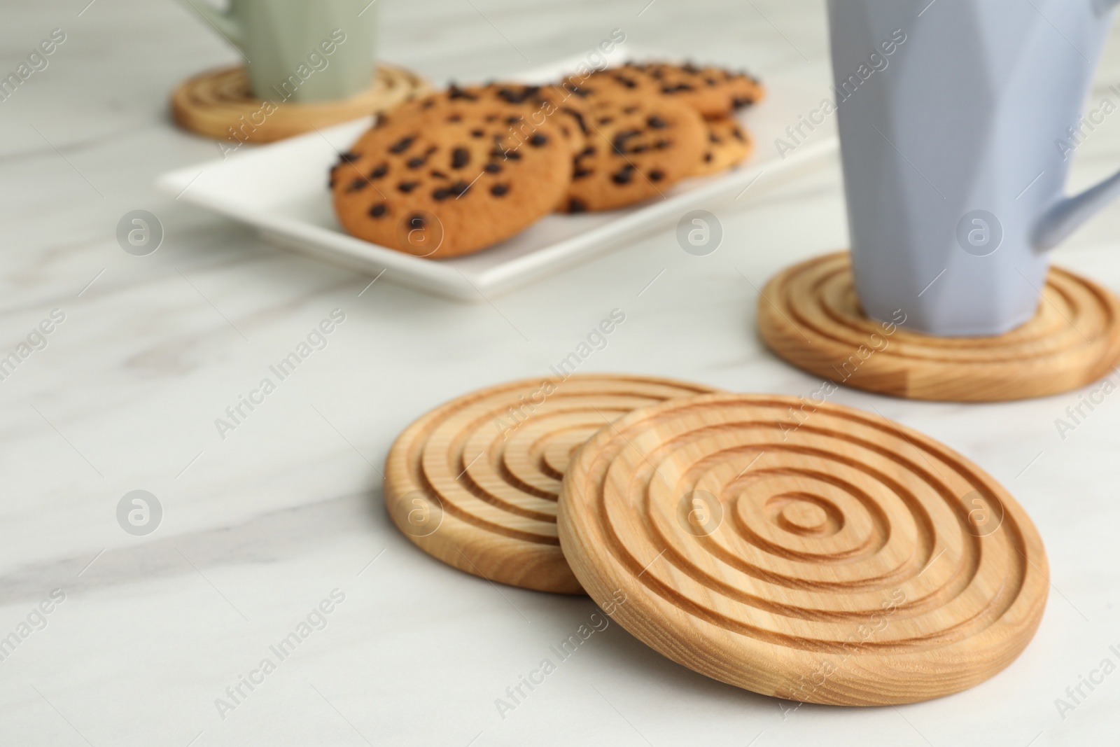 Photo of Stylish wooden cup coasters on white table, space for text