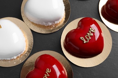 Photo of St. Valentine's Day. Delicious heart shaped cakes on black table, closeup