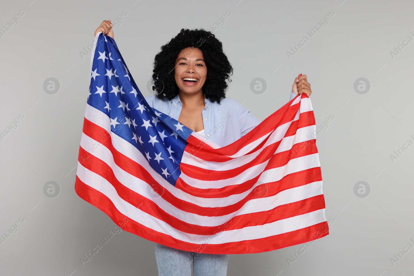 Photo of 4th of July - Independence Day of USA. Happy woman with American flag on light grey background