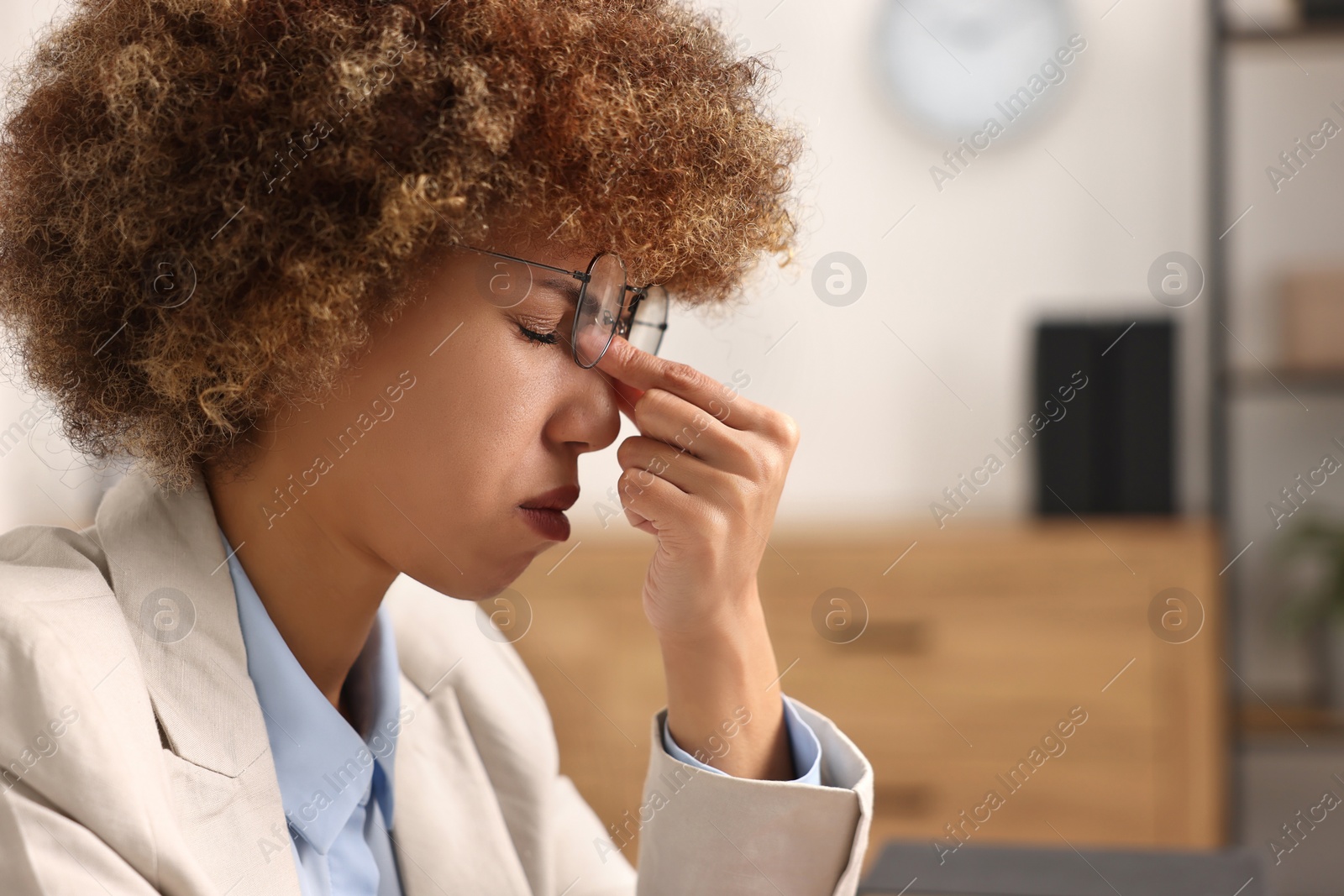 Photo of Woman suffering from headache in office, space for text