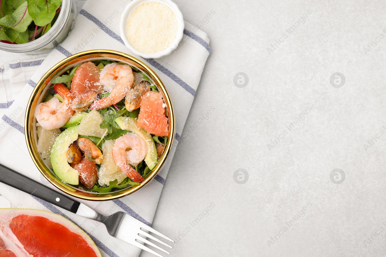 Photo of Delicious pomelo salad with shrimps served on light grey table, flat lay. Space for text