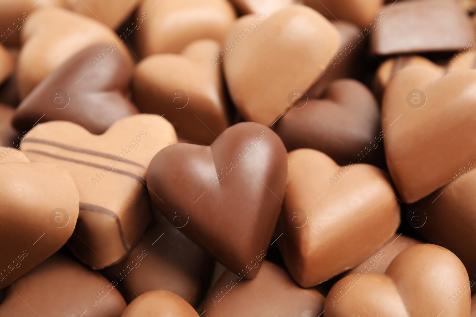 Photo of Tasty heart shaped chocolate candies as background, closeup. Valentine's day celebration