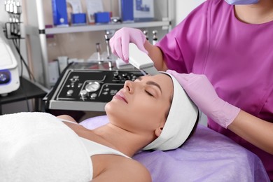 Photo of Young woman undergoing cosmetic procedure in beauty salon. Microcurrent therapy