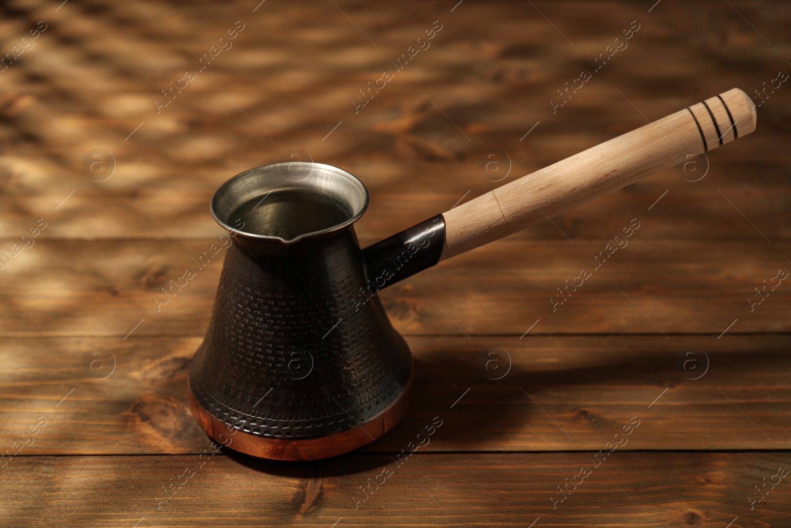 Photo of Beautiful copper turkish coffee pot on wooden table