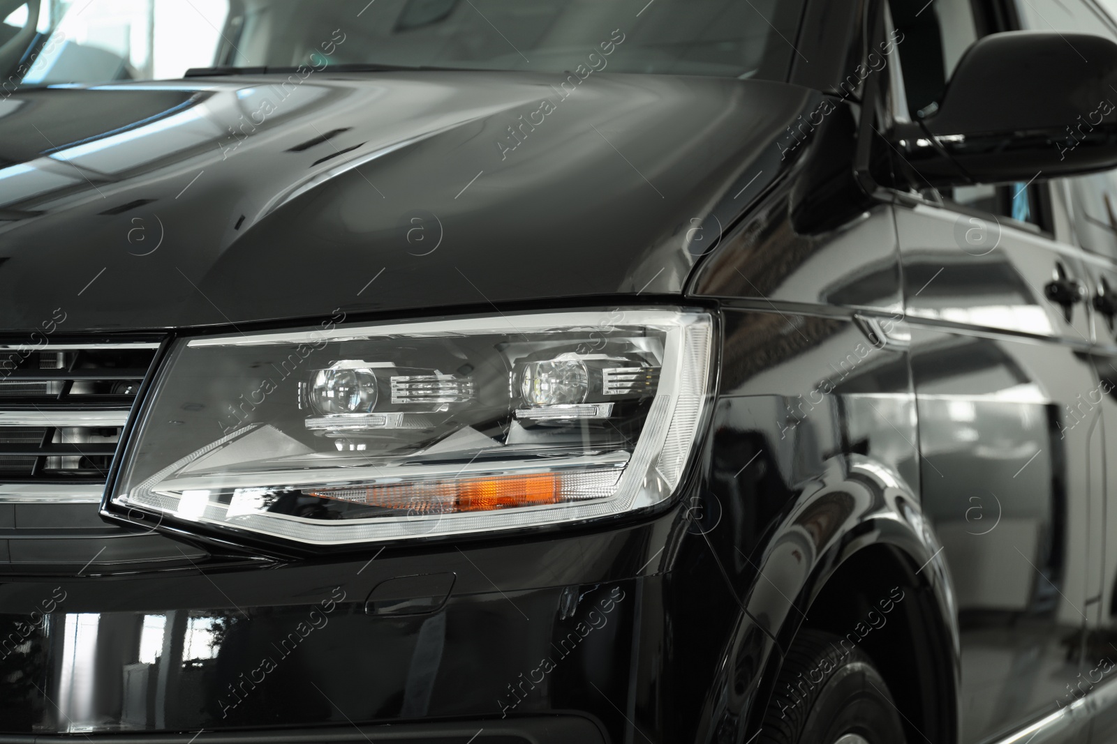 Photo of New luxury car in modern auto dealership, closeup