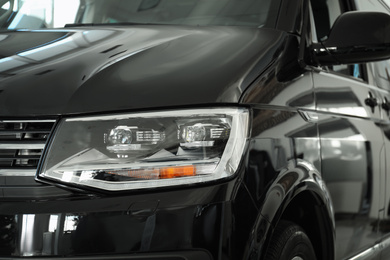 Photo of New luxury car in modern auto dealership, closeup