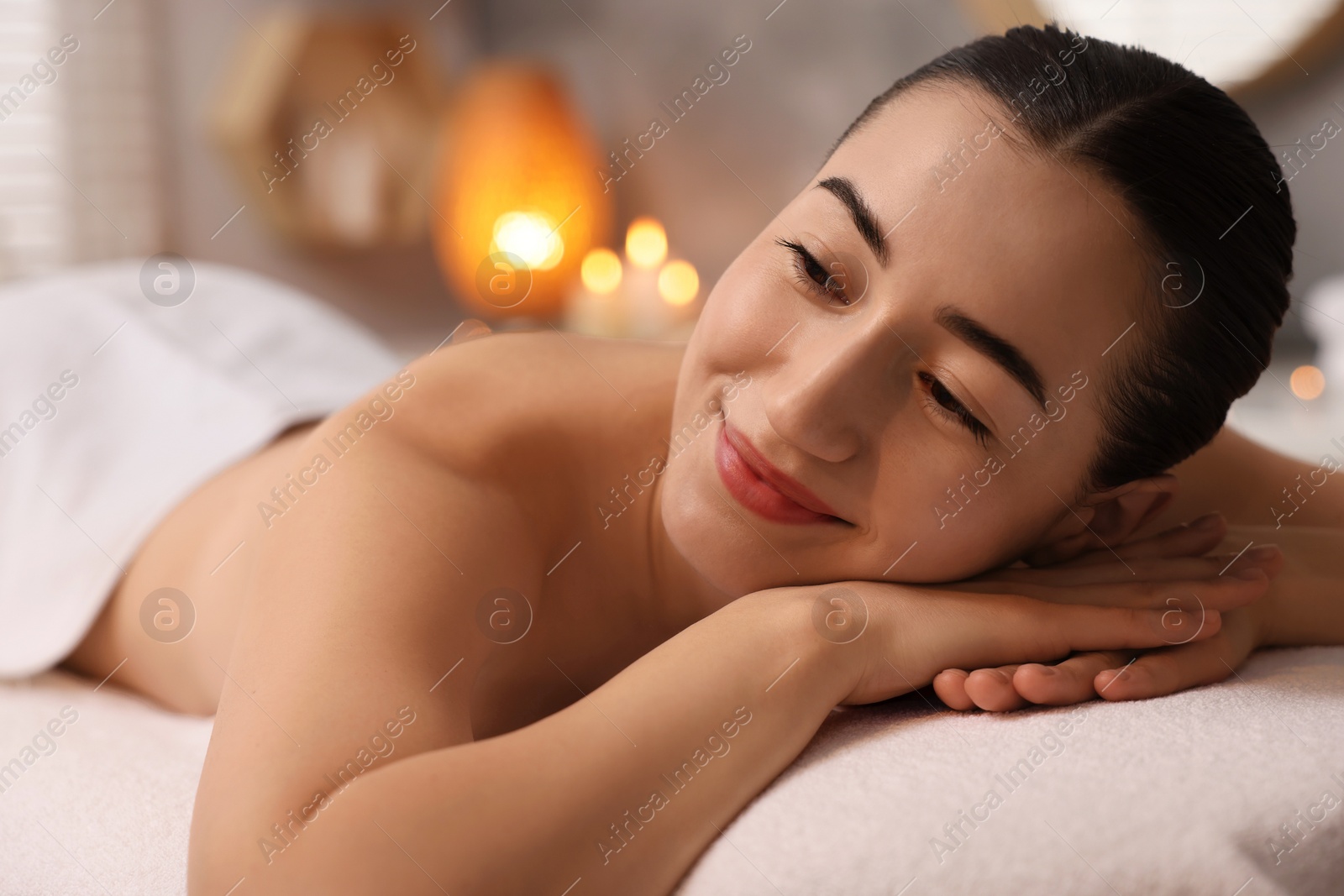 Photo of Beautiful woman relaxing on massage couch in spa salon