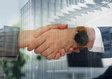 Image of Partnership concept. Double exposure of people shaking hands and buildings