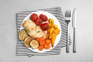 Photo of Delicious cooked chicken and vegetables served on grey table, flat lay. Healthy meals from air fryer