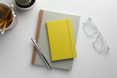Photo of Flat lay composition with notebooks and pen on white table