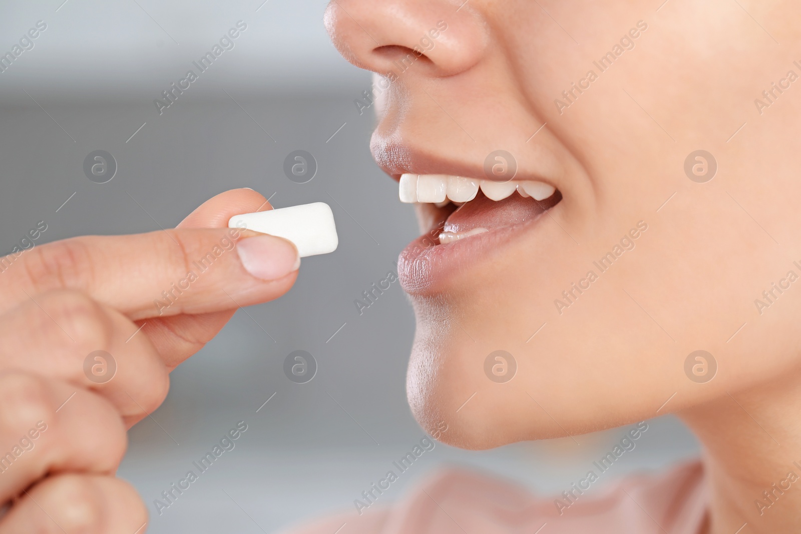 Photo of Woman with chewing gum on blurred background, closeup