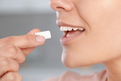 Woman with chewing gum on blurred background, closeup