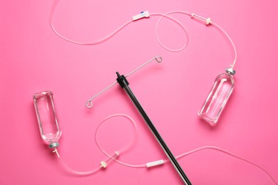 Photo of IV infusion set on pink background, flat lay
