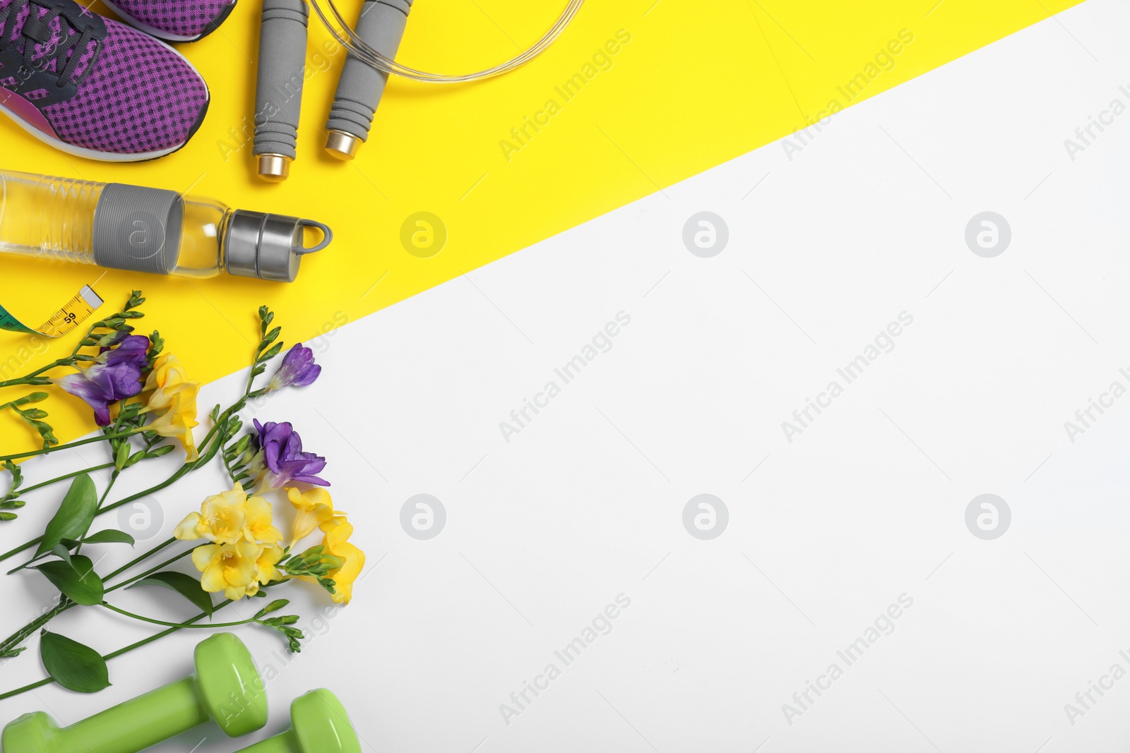 Photo of Flat lay composition with spring flowers and sports items on color background. Space for text