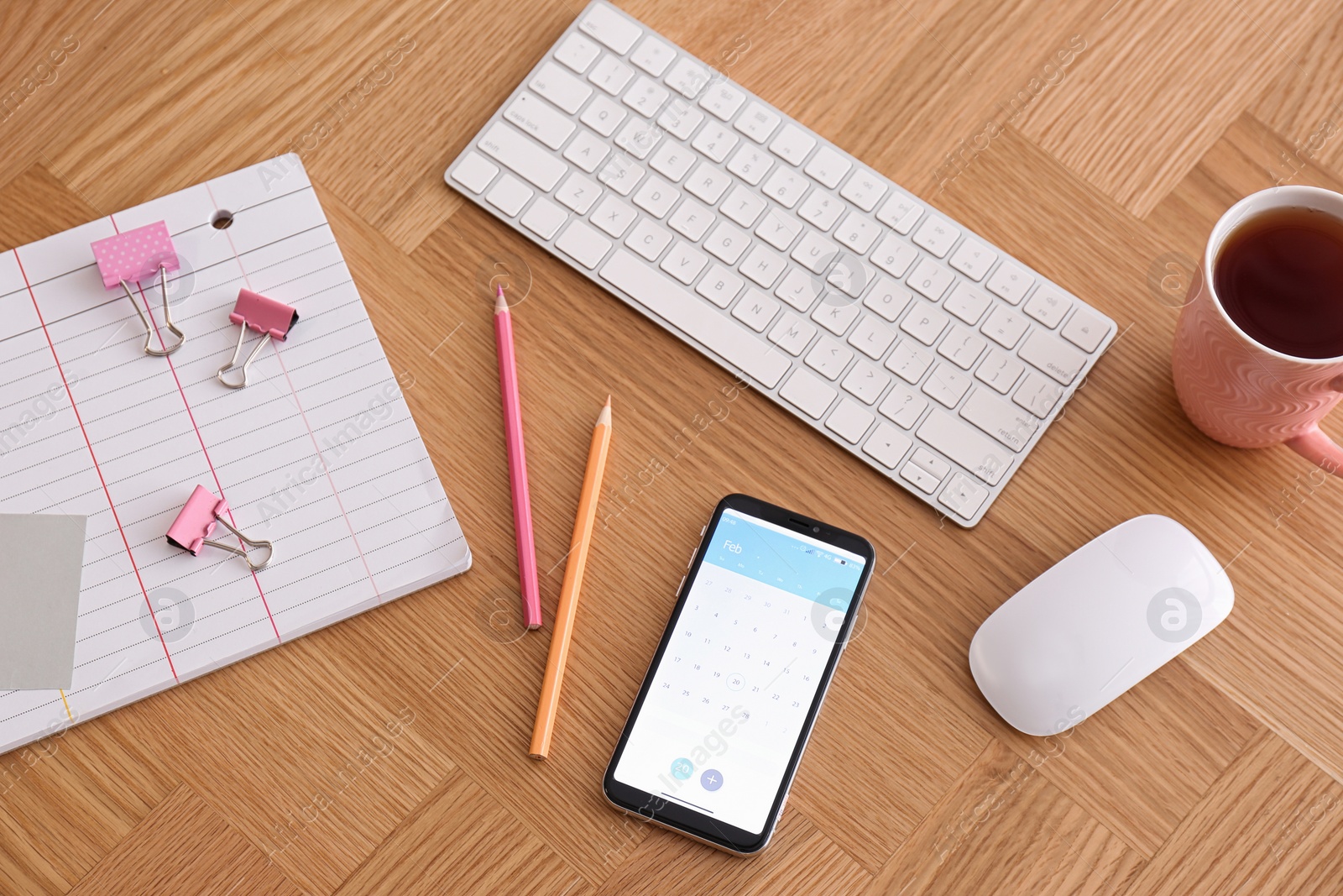 Photo of Smartphone with calendar app on wooden table, above view