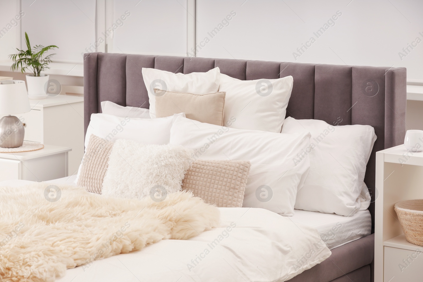 Photo of Stylish soft light bedroom interior with large comfortable bed