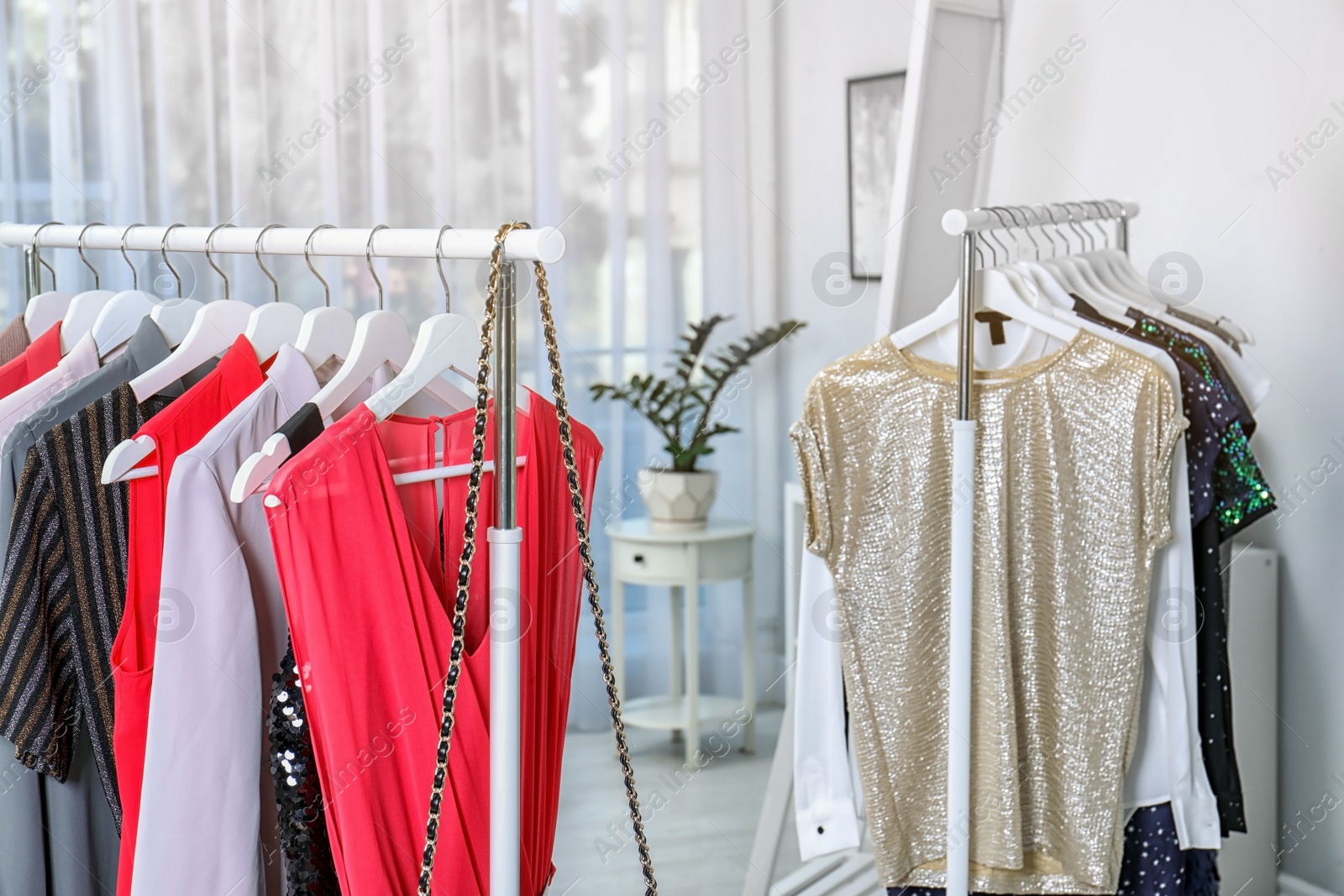 Photo of Wardrobe racks with different stylish clothes in light room