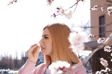 Photo of Woman suffering from seasonal allergy outdoors on sunny day