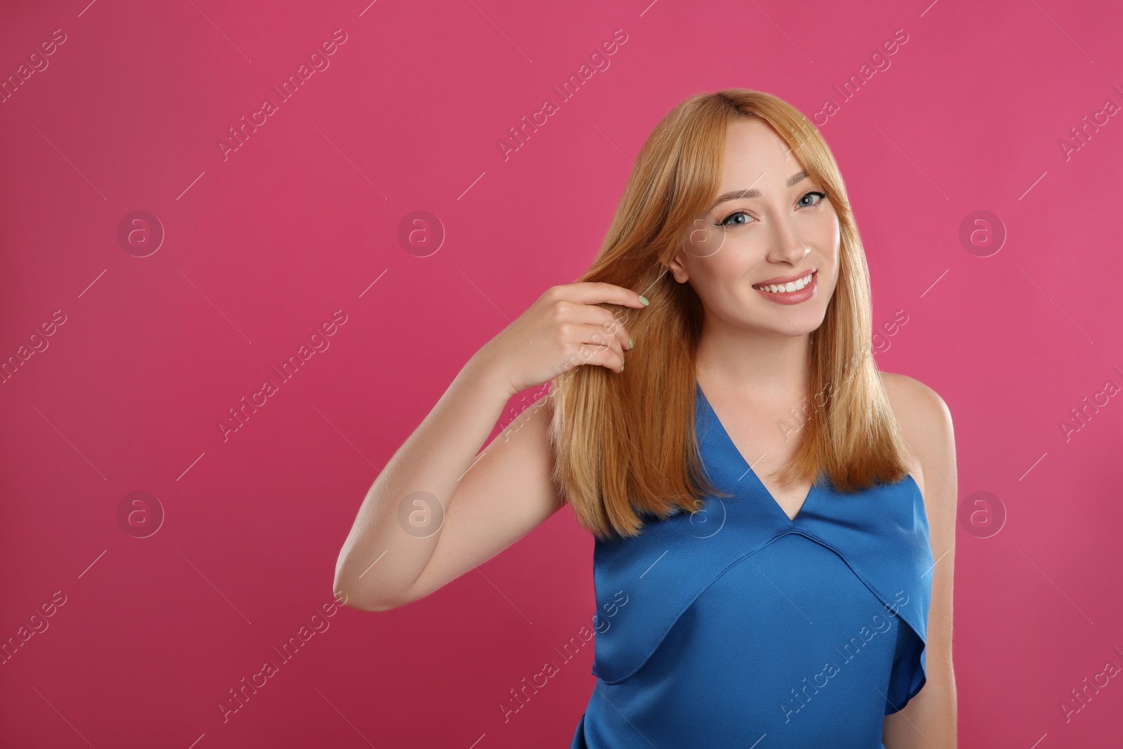 Photo of Beautiful young woman with blonde hair on pink background