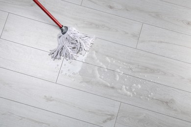 Photo of Cleaning wooden floor with mop, above view. Space for text
