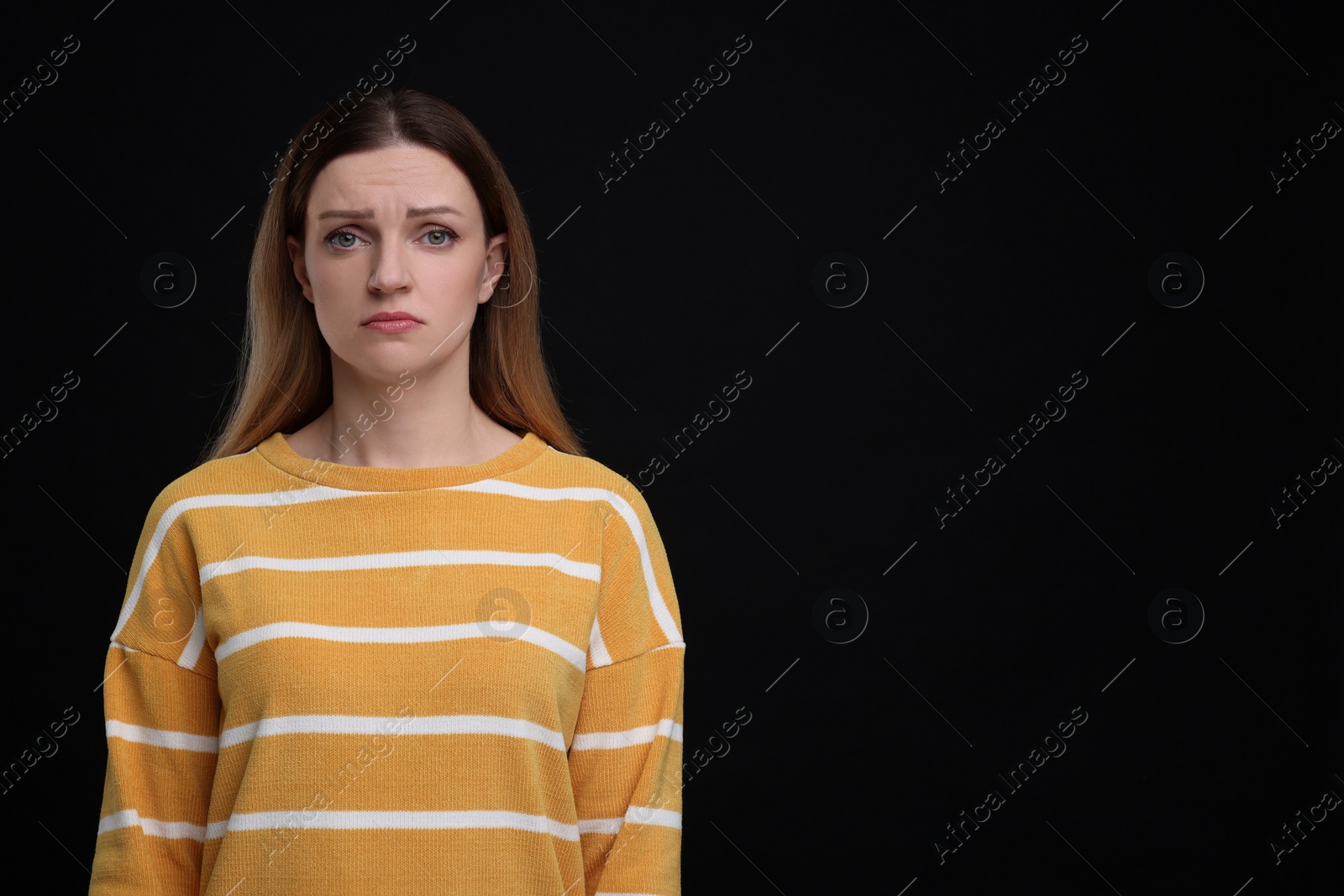 Photo of Portrait of sad woman on black background, space for text