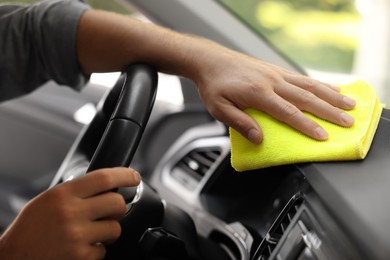 Photo of Man cleaning car interior with rag, closeup