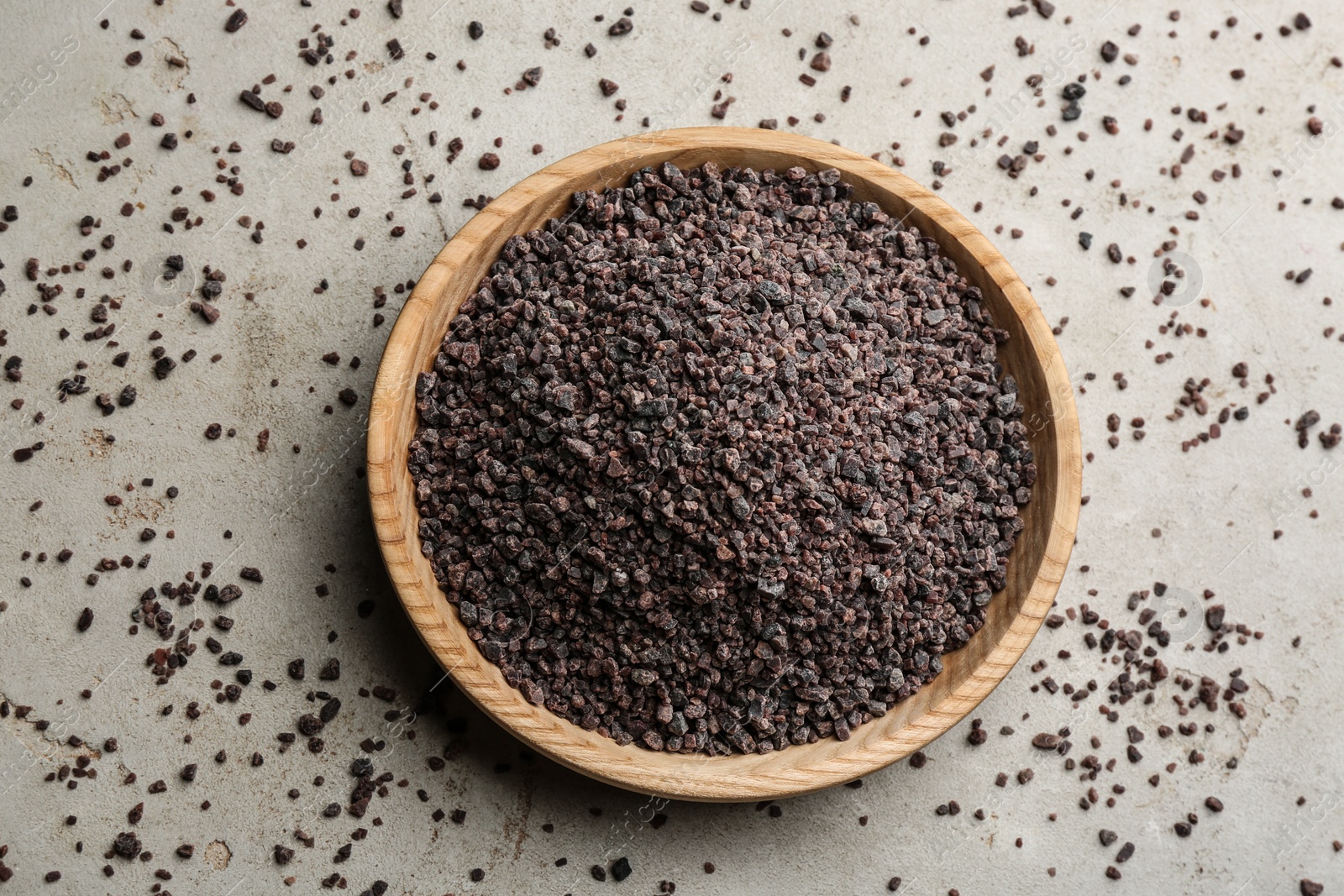 Photo of Black salt on grey table, flat lay