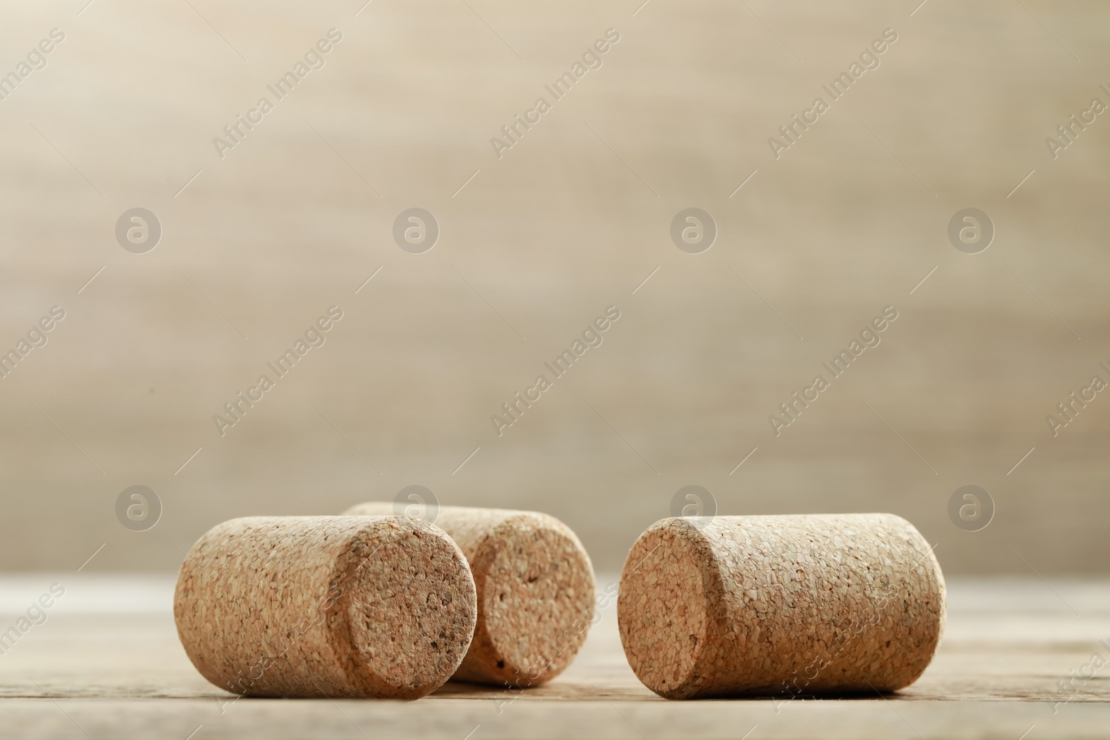 Photo of Corks of wine bottles on wooden table, space for text