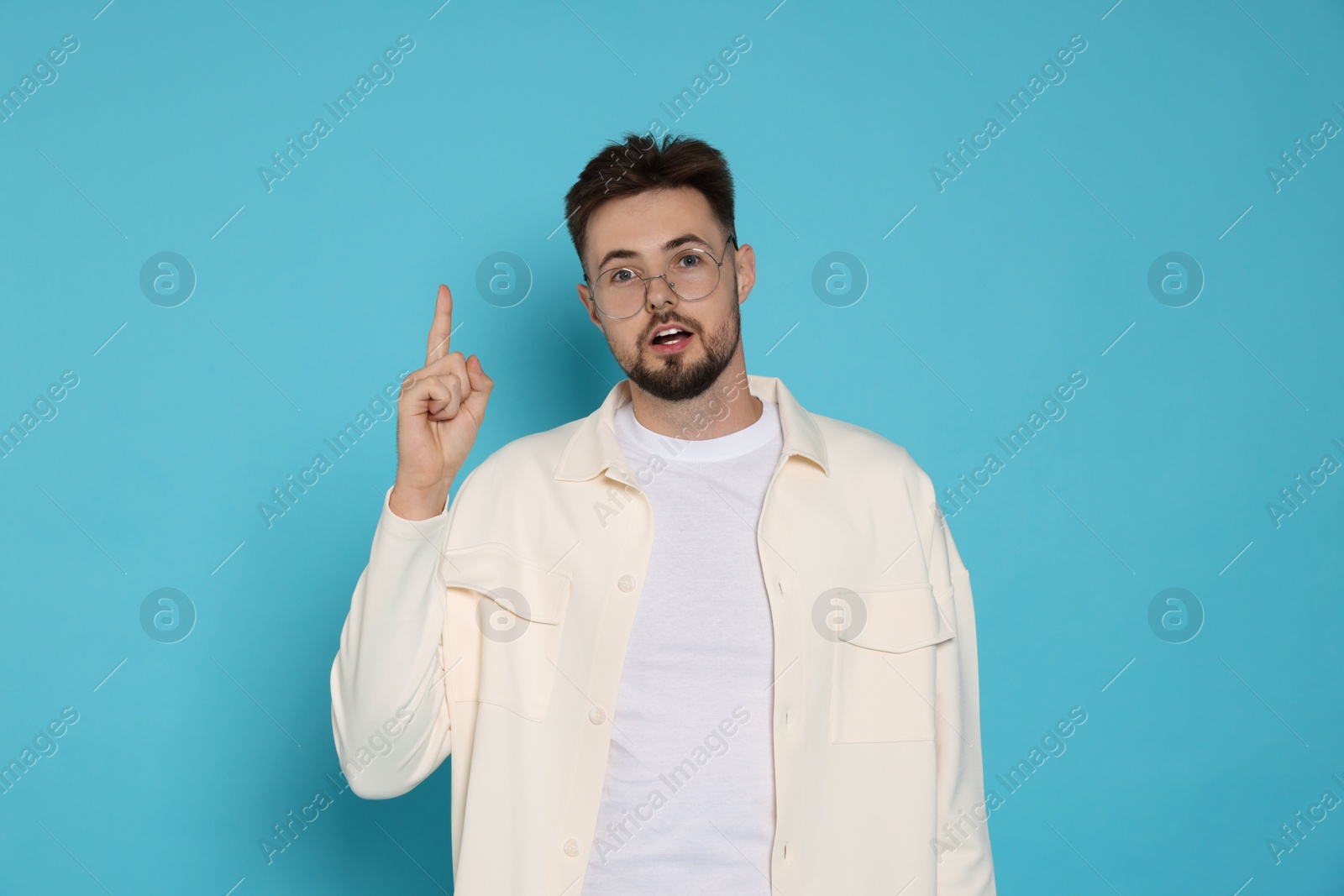 Photo of Handsome man in white jacket on light blue background