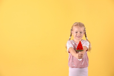 Cute little girl with candy on color background. Space for text