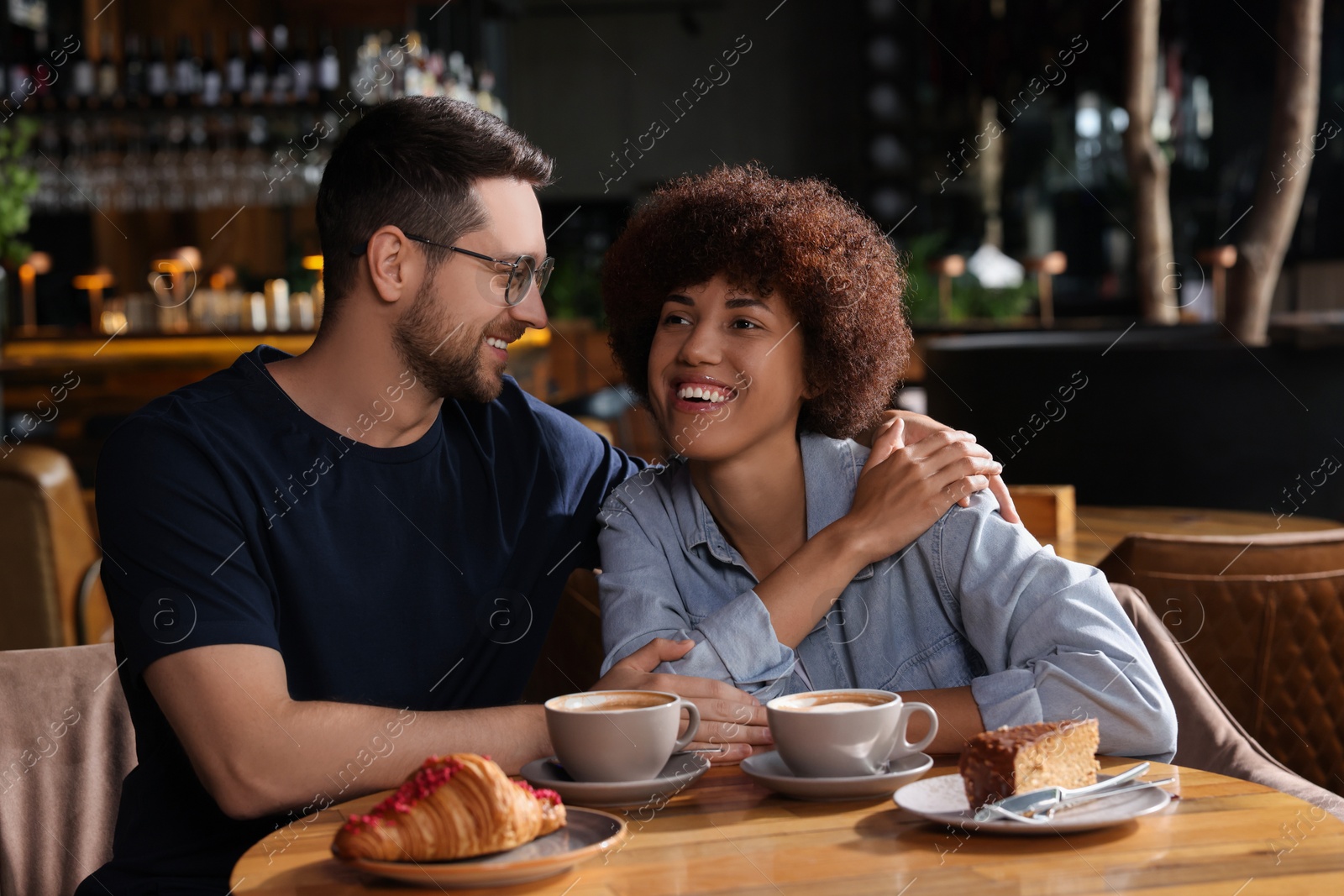 Photo of International dating. Lovely couple spending time together in cafe