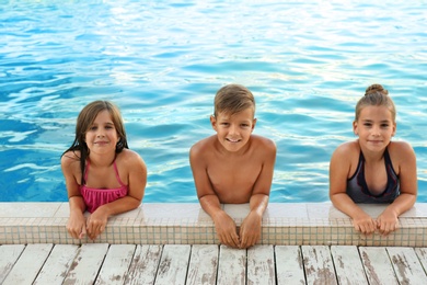 Happy children in swimming pool on sunny day