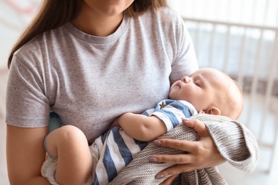 Photo of Mother with her sleeping baby at home, closeup view