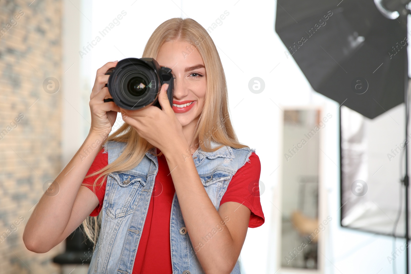 Photo of Professional photographer with camera in photo studio