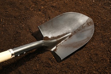 Photo of Metal shovel on fertile soil. Gardening tool