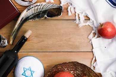 Photo of Frame of Rosh Hashanah holiday attributes on wooden table, flat lay. Space for text