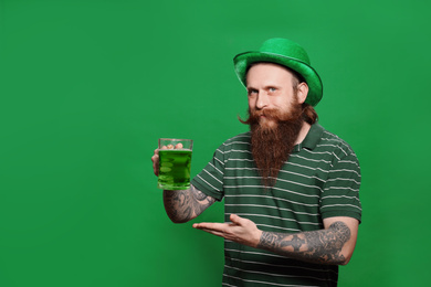 Bearded man with green beer on color background. St. Patrick's Day celebration