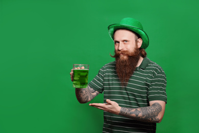 Photo of Bearded man with green beer on color background. St. Patrick's Day celebration