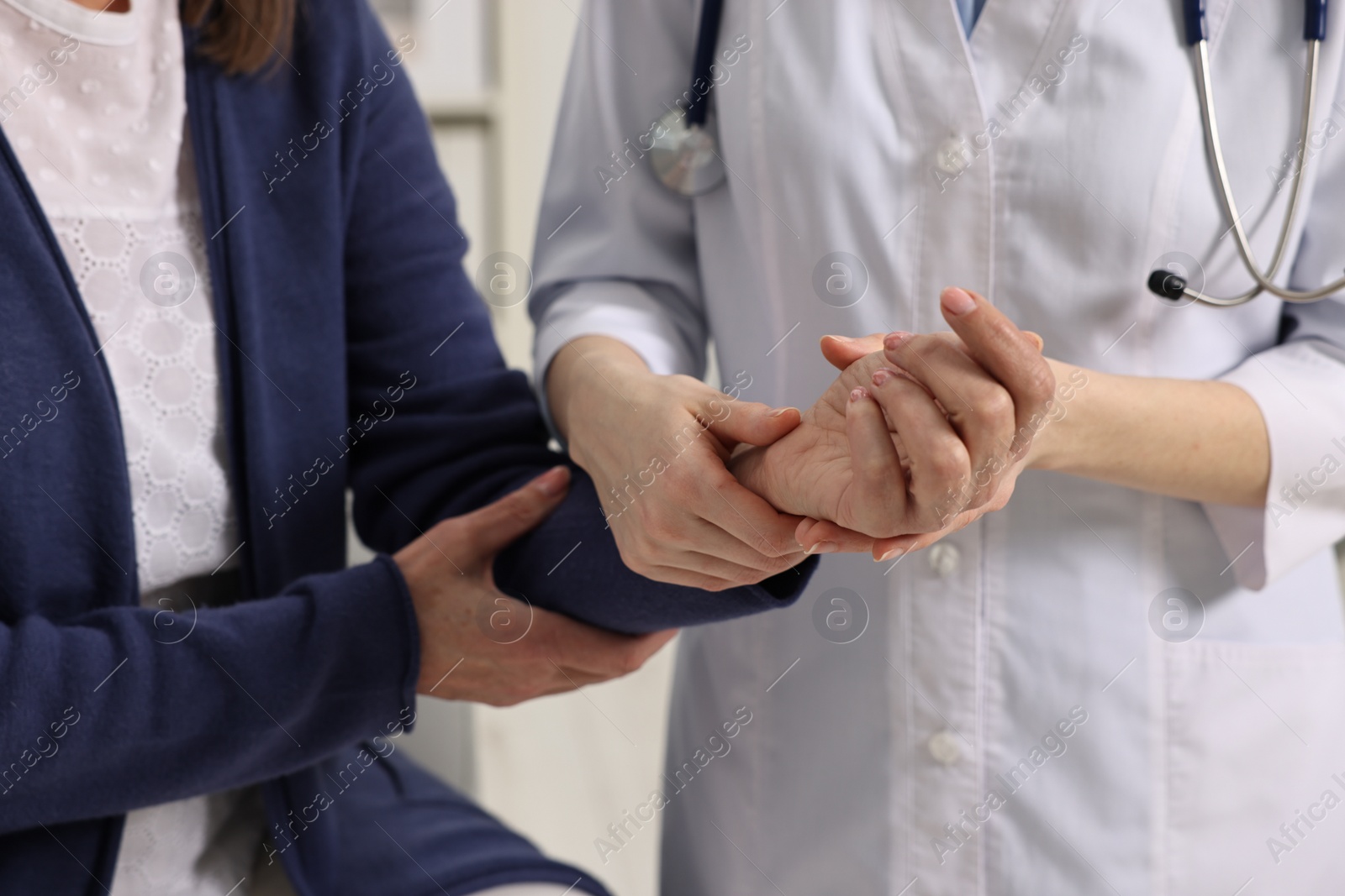 Photo of Arthritis symptoms. Doctor examining patient's wrist in hospital, closeup