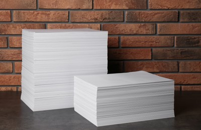 Photo of Stacks of paper sheets on black table