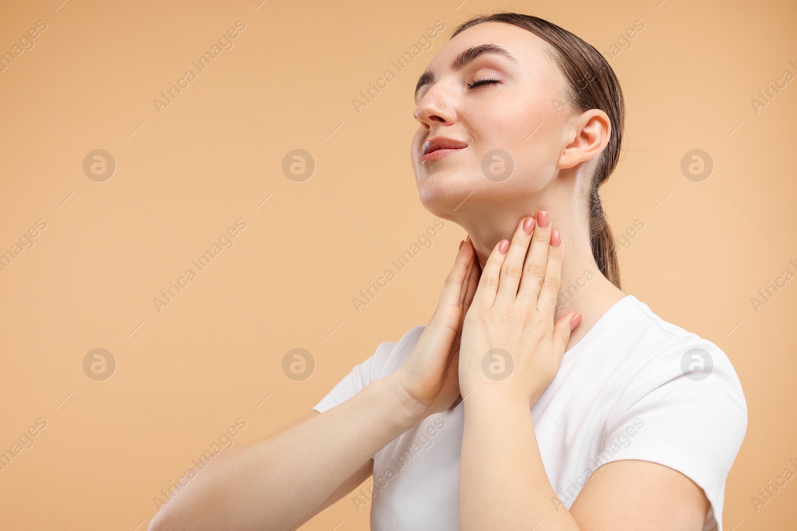 Photo of Beautiful woman touching her neck on beige background. Space for text
