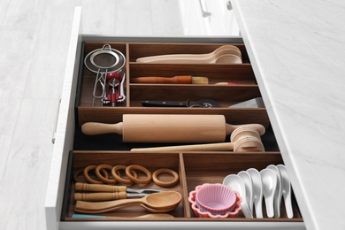 Photo of Drawer with utensil set, closeup. Order in kitchen