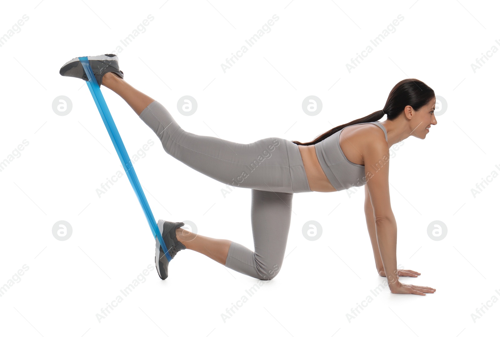 Photo of Woman doing sportive exercise with fitness elastic band on white background